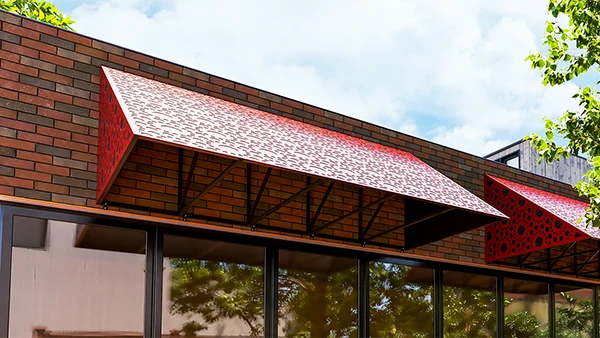Red metal awning over cafe windows with a decorative pattern