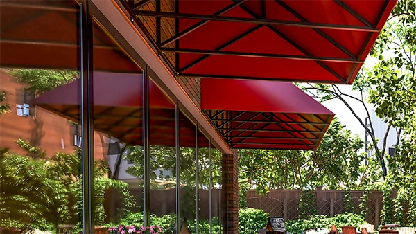 Red metal awning over cafe windows looking up